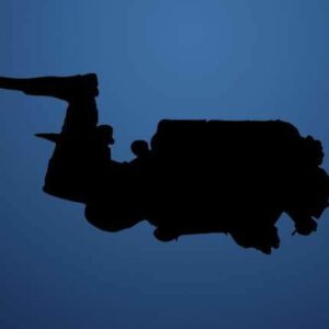 Silhouette of a solo diver with doubles in profile.