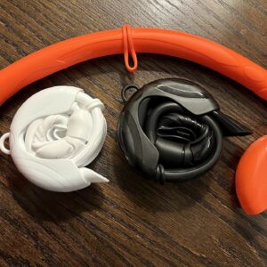 Three foldable silicone snorkels of different color: orange, black, and white.