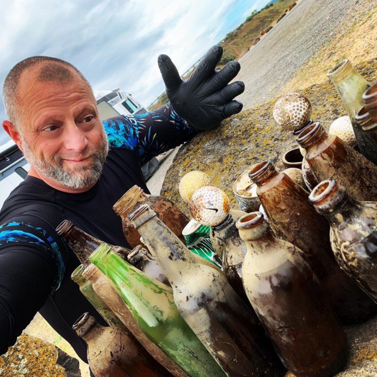 A diver showing off the trash pulled out from lost lake diving.