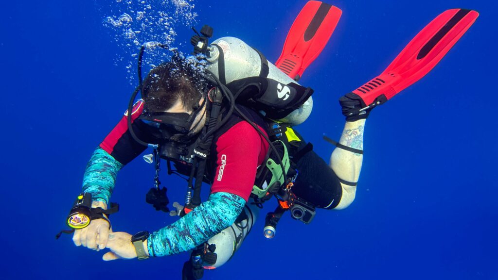 A scuba diver floating effortlessly in the water column after a deep dive in Cozumel, Mexico.