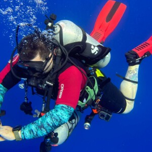 A scuba diver floating effortlessly in the water column after a deep dive in Cozumel, Mexico.