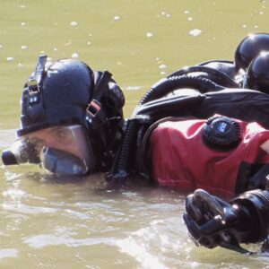 A public safety diver in contaminated water with a full face mask and environmentally protected dry suit.
