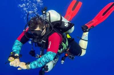 A scuba diver floating effortlessly in the water column after a deep dive in Cozumel, Mexico.